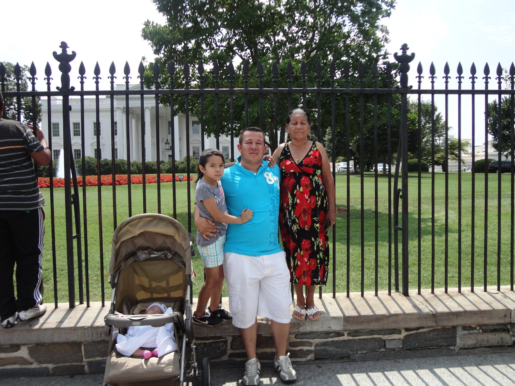 Family gathered near the White House fence with a stroller