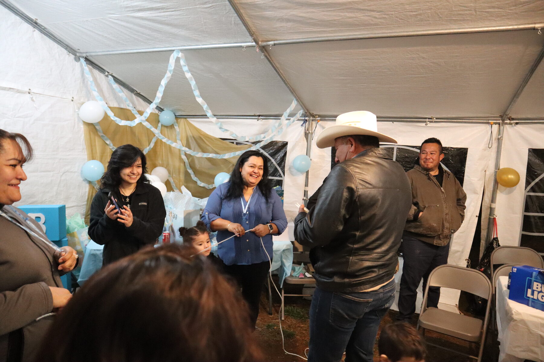 Family and friends gathered beneath a tent
