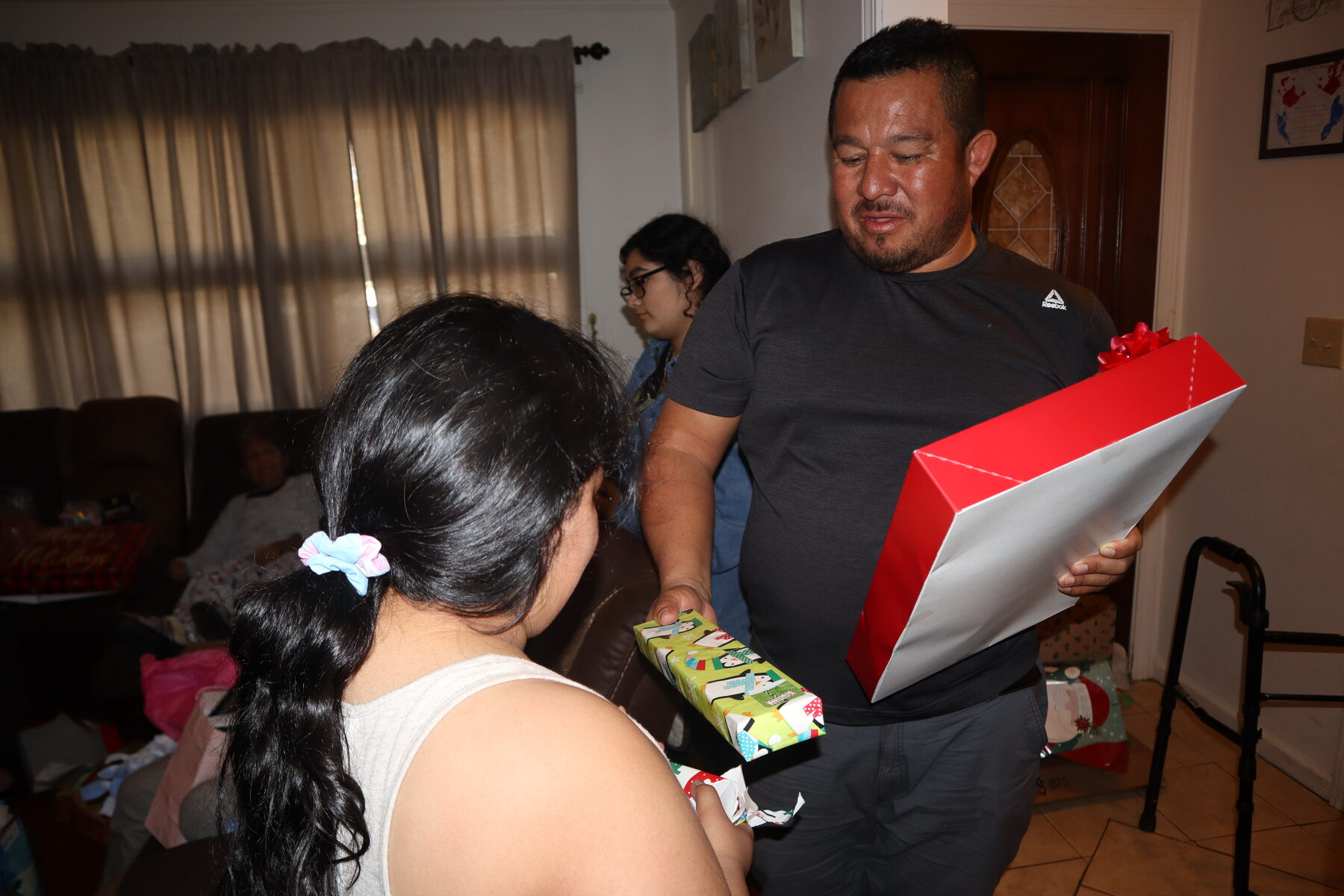 Homero opening a Christmas present at home