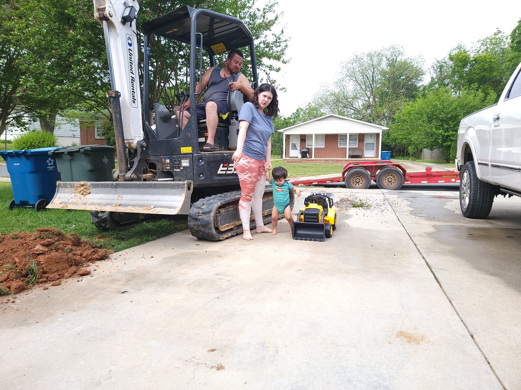 Homero and family gathered around an excavator in a driveway