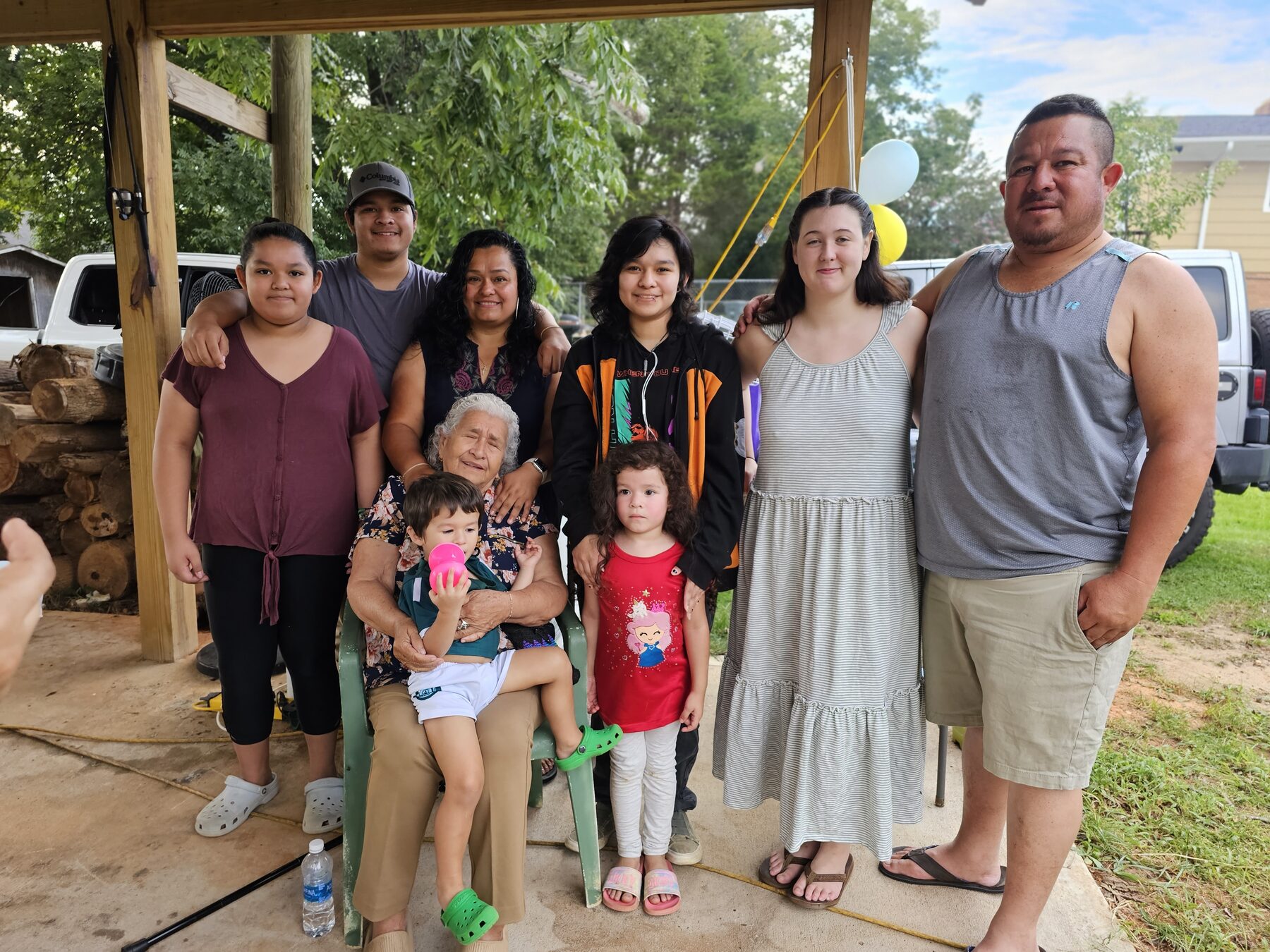 Homero posing outdoors with a large family group