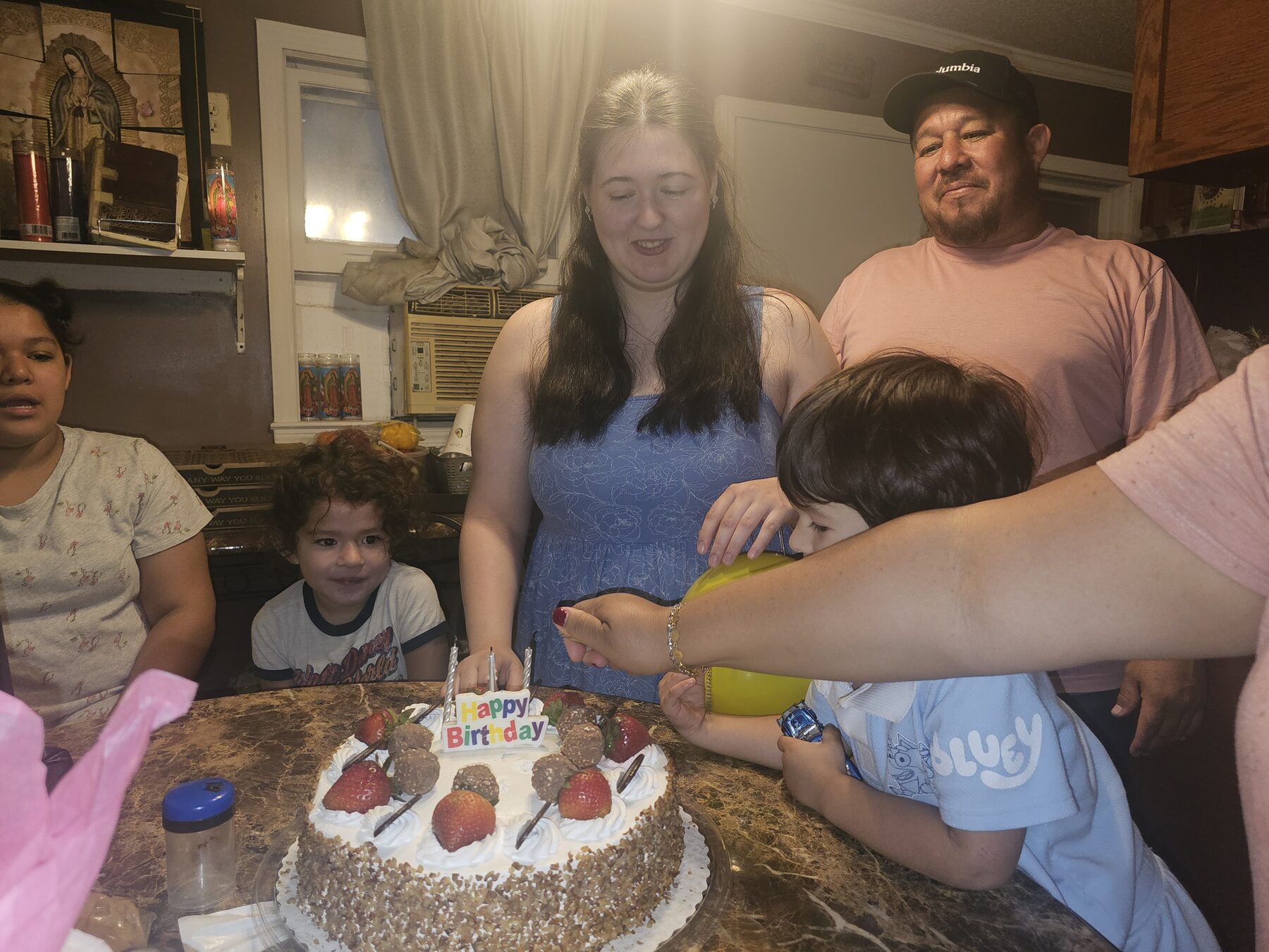 Family gathered around a birthday cake