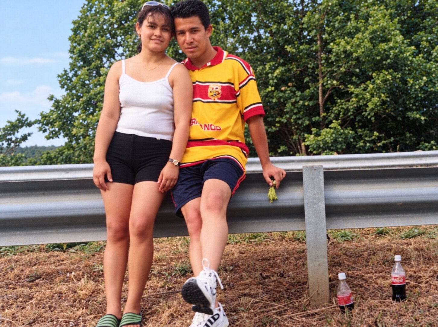 My dad and my mom together beside a roadside guardrail